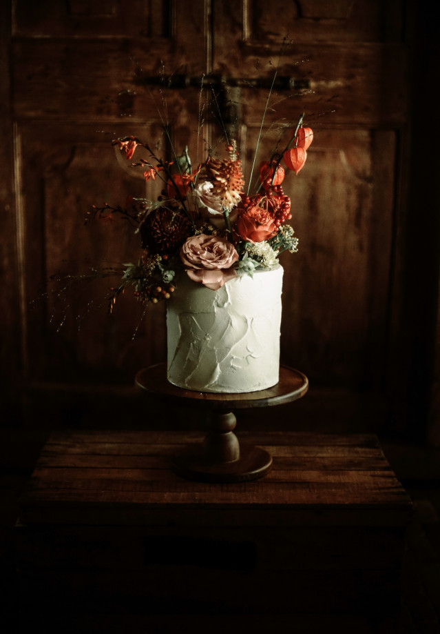 Einstöckige Hochzeitstorte mit dunklen Blumen