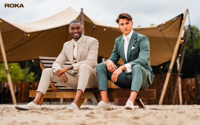 twee mannen in pakken die op een bank zitten