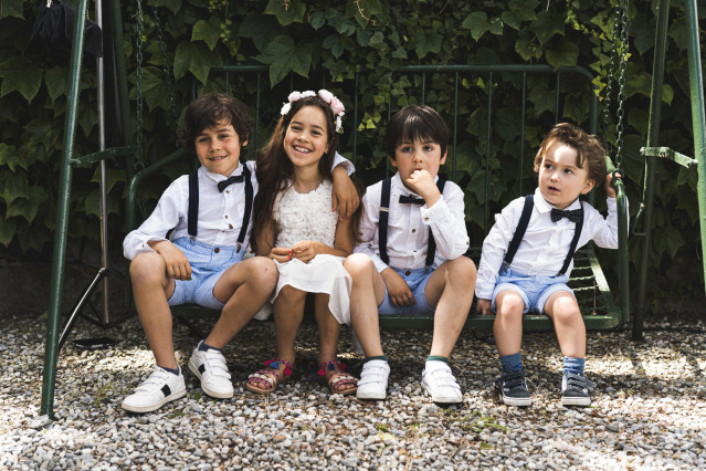 Bambini in abiti eleganti seduti su una panchina