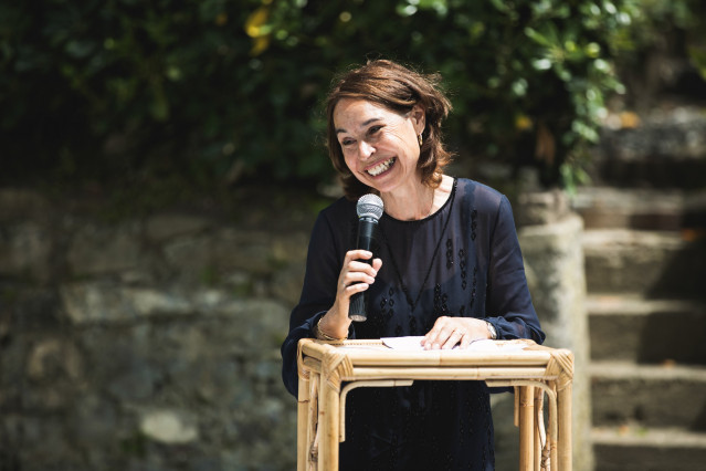Donna con microfono in mano che tiene un discorso durante una cerimonia