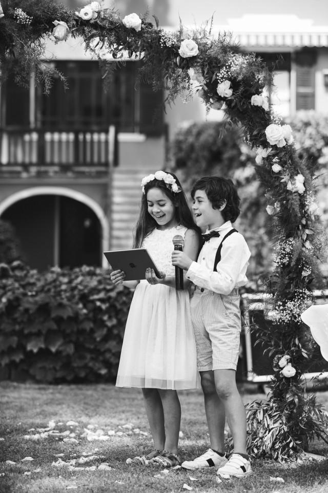 Black and white image of a boy and girl with a microphone giving a speech.