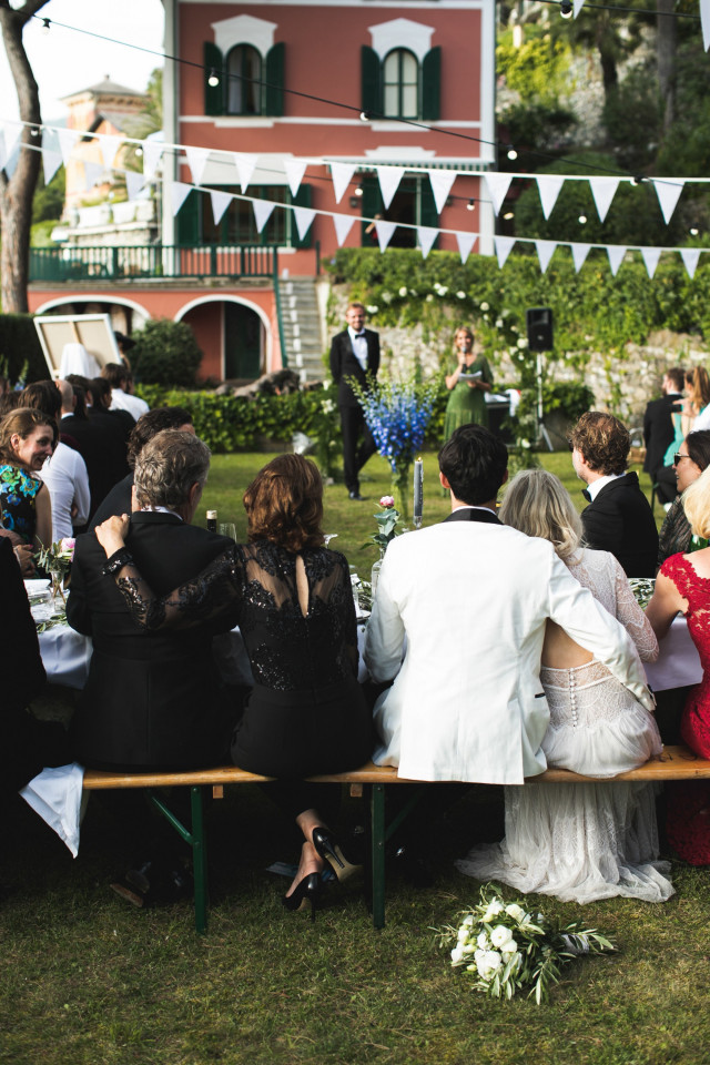 Immagine di persone a un matrimonio sittingin in una panchina, ascoltando un discorso