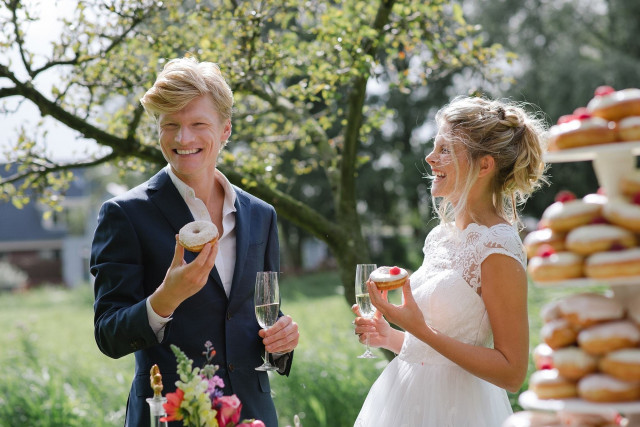 bruidspaar met donuts op bruiloft