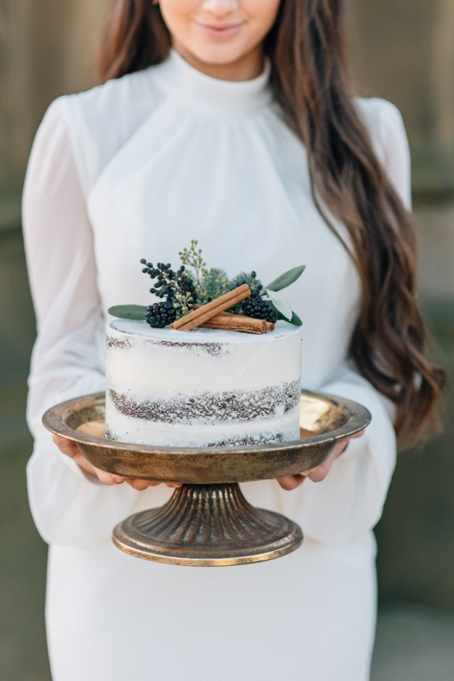 Hochzeitstorte mit Beeren und Zimtstangenverzierung