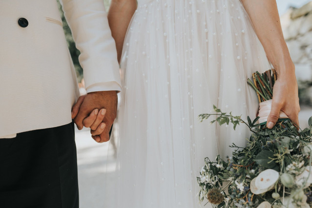 A detail photo of the couple's intertwined hands resting together.
