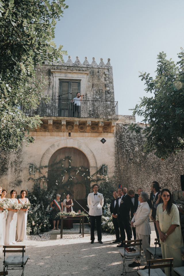 The groom waits at the villa archway as the ceremony is about to begin.