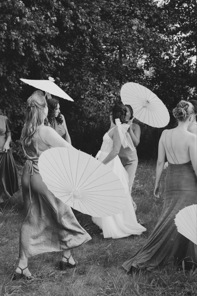 een zwart-wit foto van een groep vrouwen met paraplu's
