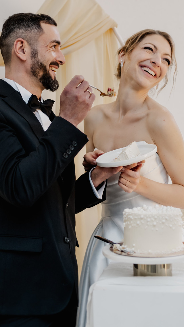 Brautpaar isst Hochzeitstorte mit Perlen Verziehrung