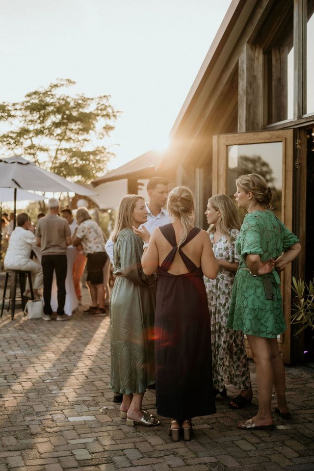 bruiloftsgasten buiten trouwlocatie tijdens borrel