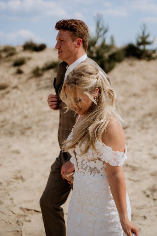 Couple in relaxed beach wedding attire on the dunes
