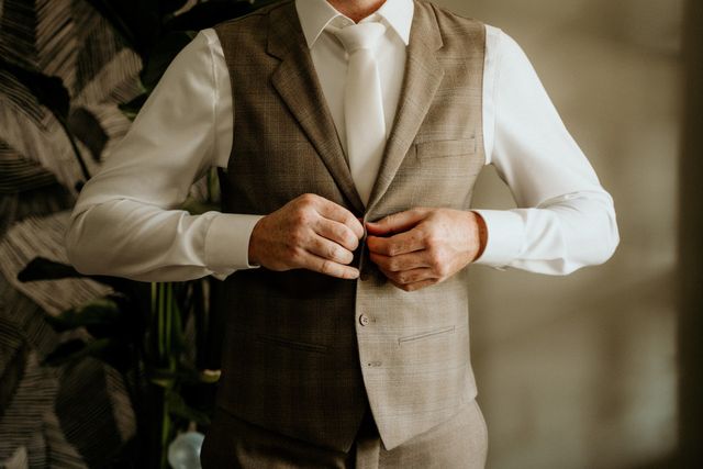 le mari&eacute; enfile son costume de mariage