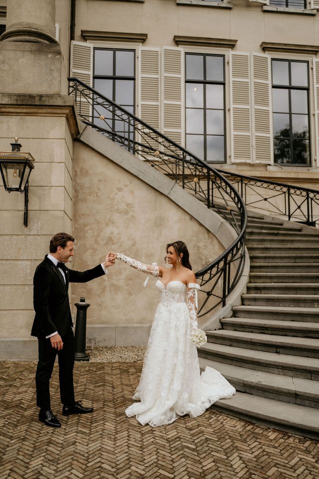 Couple in black tie wedding attire on a grand staircase