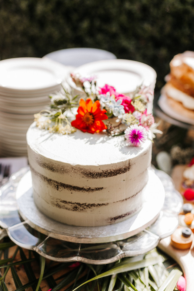 Witte taart met gekleurde bloemen erop