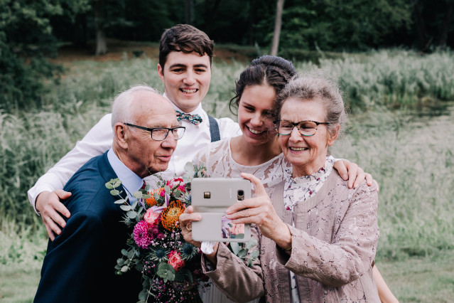 een familie maakt een selfie met hun bruiloftsgasten