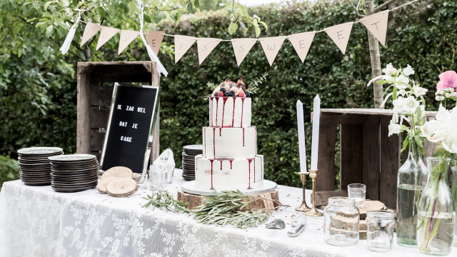 Sweet table met witte taart met roze dripping in het midden