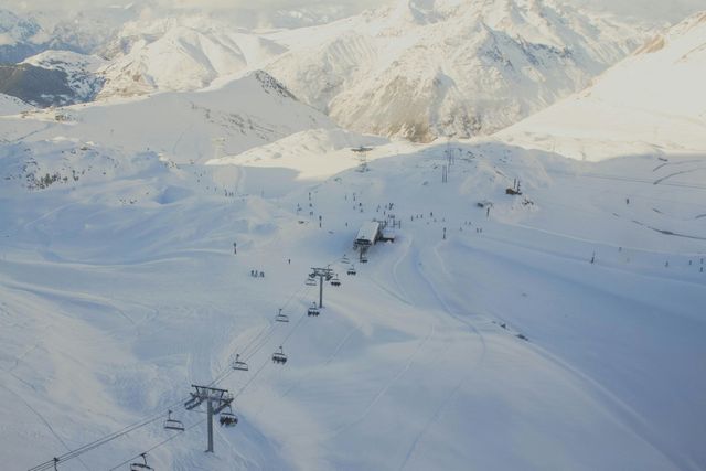 Vogelansicht einer Skipiste, die halb im Schatten liegt