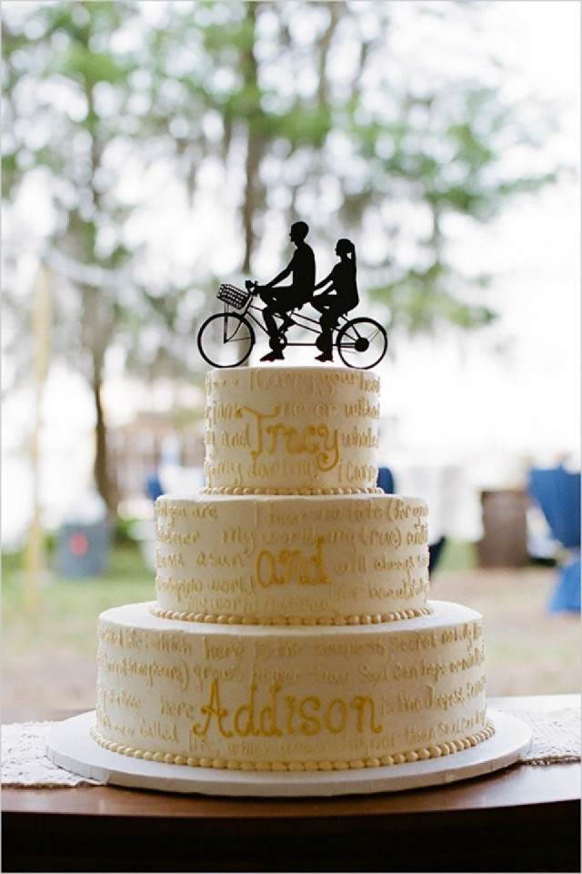 Hochzeitstorte mit Tortentopper der Menschen auf einem Tandemfahrrad zeigt