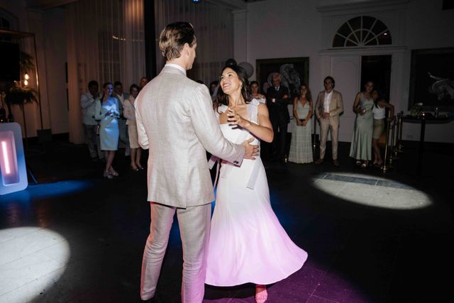 A couple dances closely together during their first dance at the reception.