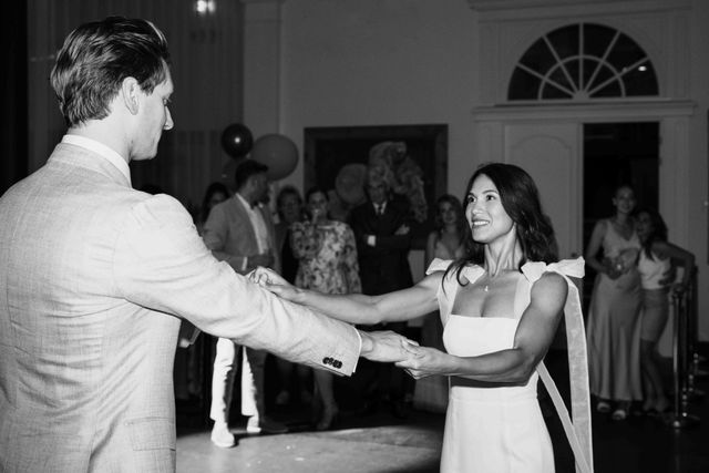 A black and white photo of the couple walking hand in hand together.
