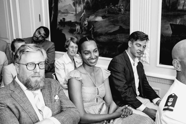 Seated guests look on, engrossed and smiling, during the ceremony.