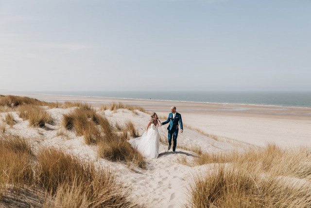 Brautpaar läuft zusammen am Strand