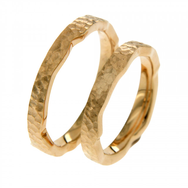 twee gouden trouwringen met een gehamerd textuur