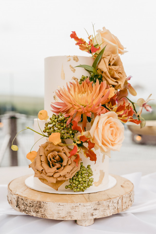 Weiße Hochzeitstorte mit orangenen Blumen
