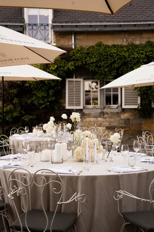 Round reception tables dressed with white roses, candles, and fine details.