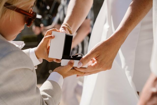 A couple shares a kiss as the groom gently holds the bride's face.