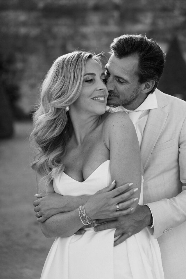 A black and white portrait of the couple in a close, intimate embrace.