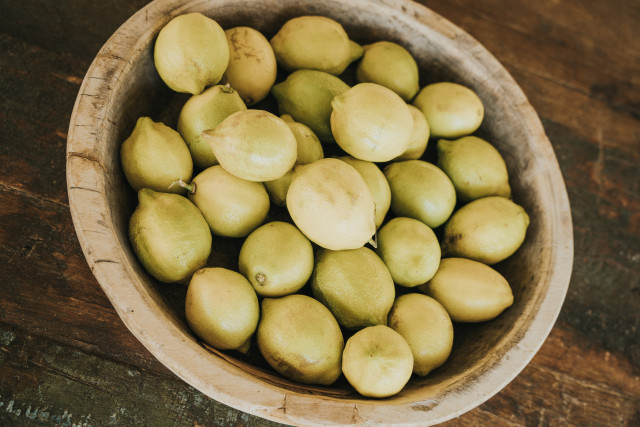 A wooden bowl filled with lemons on a weathered table at the venue.