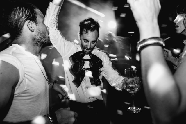 A black and white photo of a celebrating crowd packed onto the dance floor.