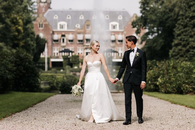 bruidspaar loopt voor trouwlocatie