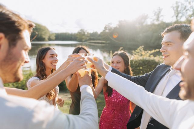 Groep vrienden proost buiten bij gouden avondlicht, aan het water