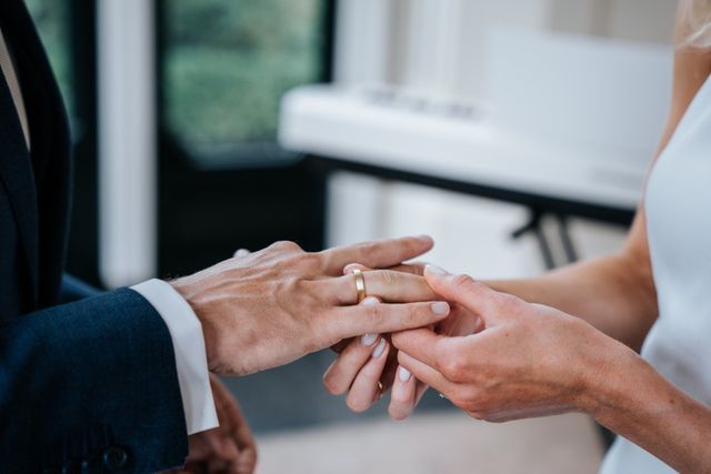 A close-up of a wedding ring being placed on a finger during the ceremony.