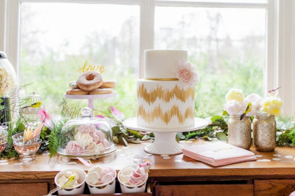 een tafel met een taart, donuts en cupcakes