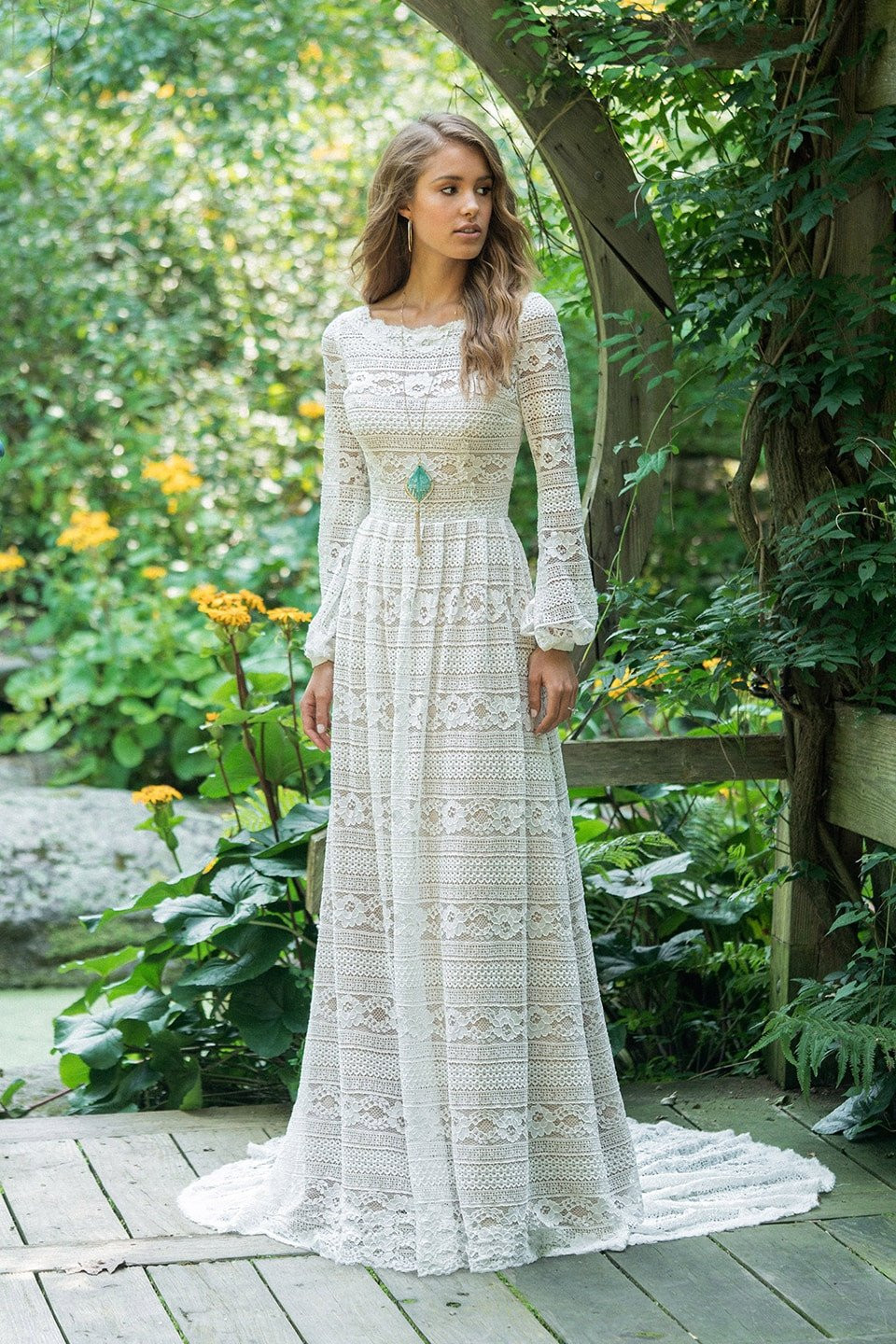 een vrouw in een trouwjurk die in de tuin staat