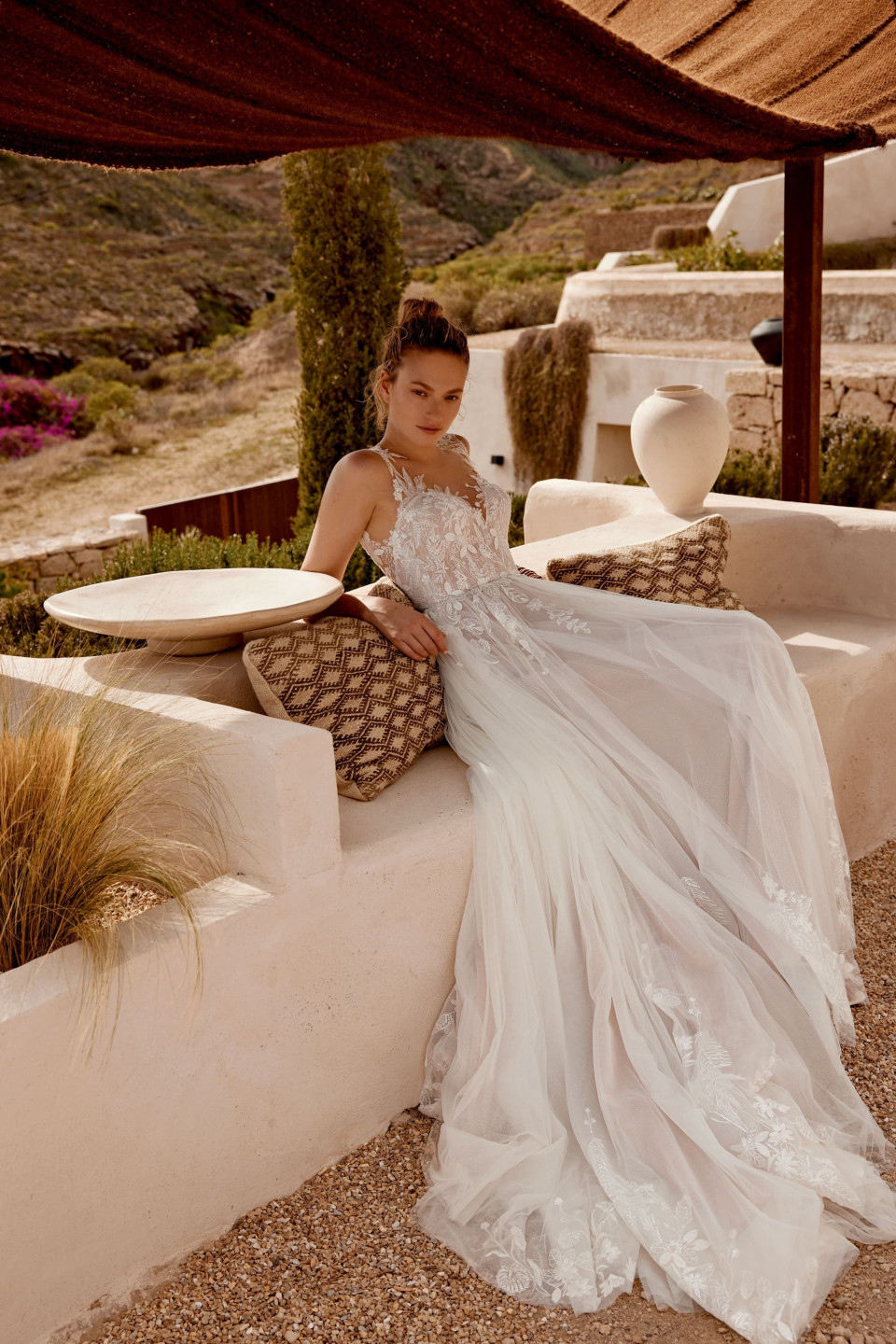 een vrouw in een trouwjurk die op een bank zit