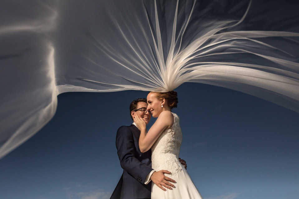 een bruid en bruidegom omhelzen onder een sluier