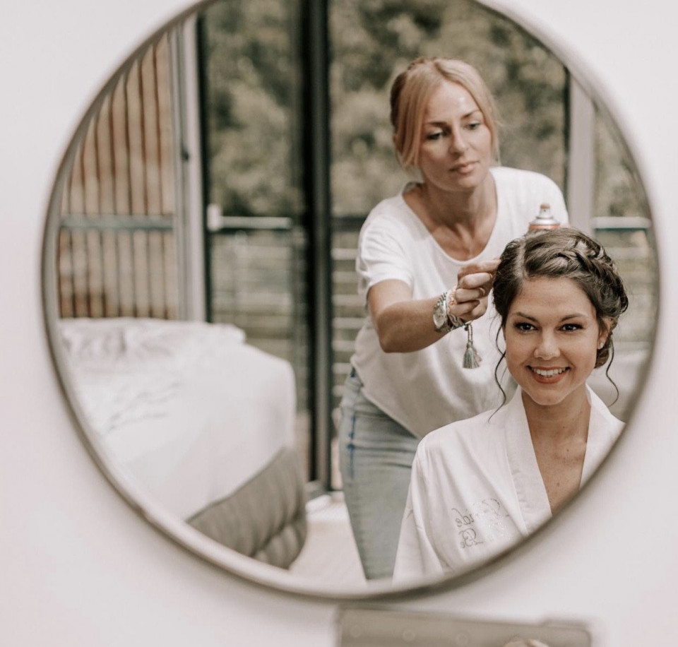 een vrouw krijgt haar haar gedaan voor een spiegel