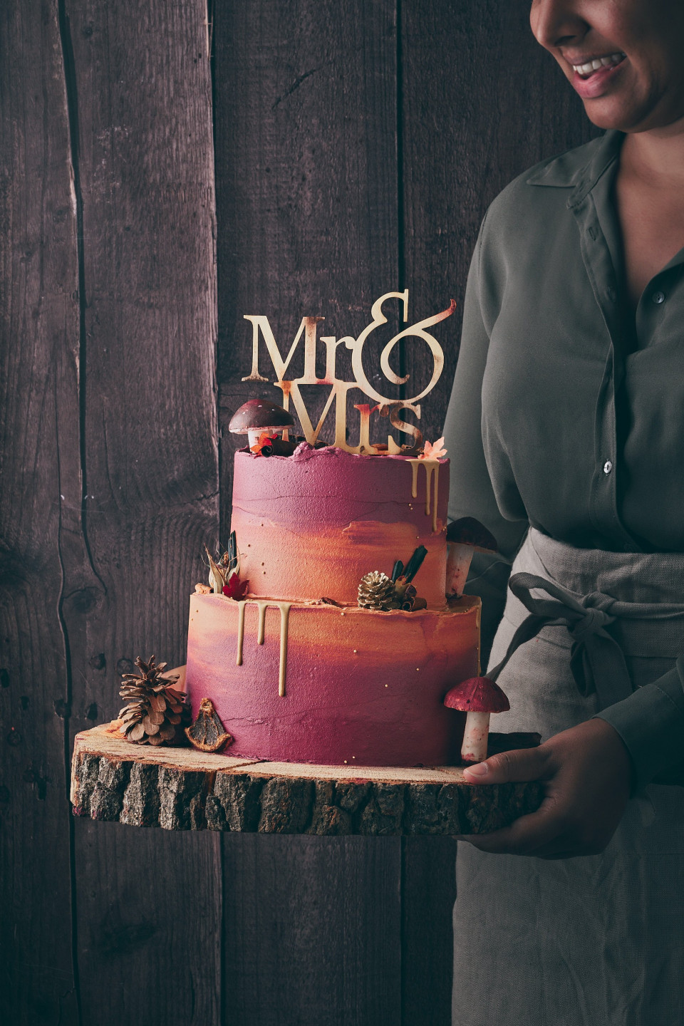 een vrouw die een taart vasthoudt met 'mr and mrs' erop