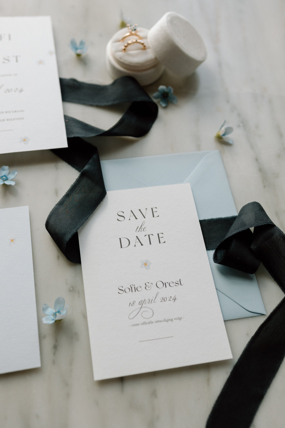 save the date kaarten met zwarte strik en blauwe bloemen