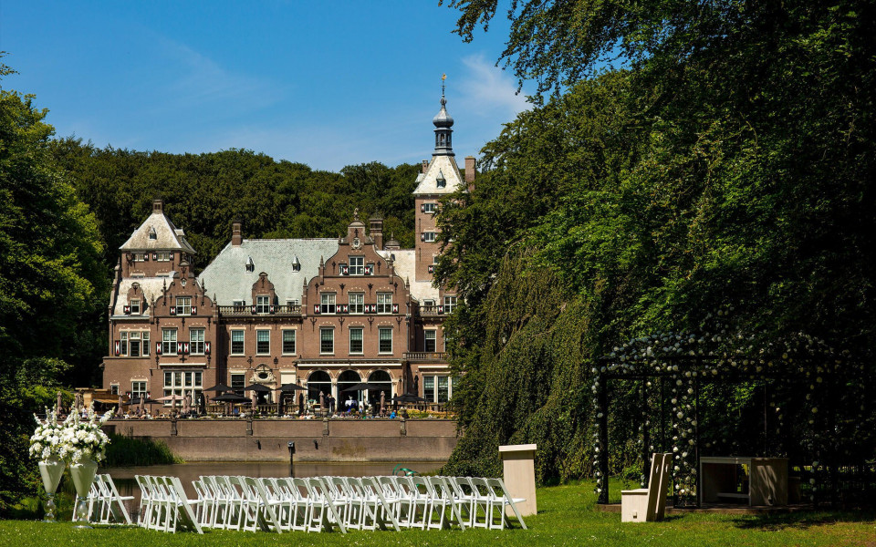 een bruiloftsceremonie vindt plaats voor een kasteel