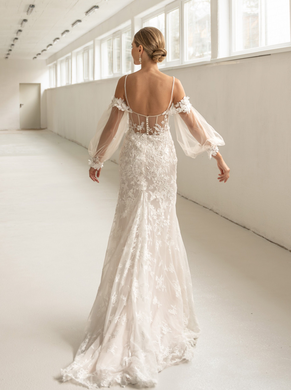 de achterkant van een vrouw die een off-shoulder trouwjurk draagt