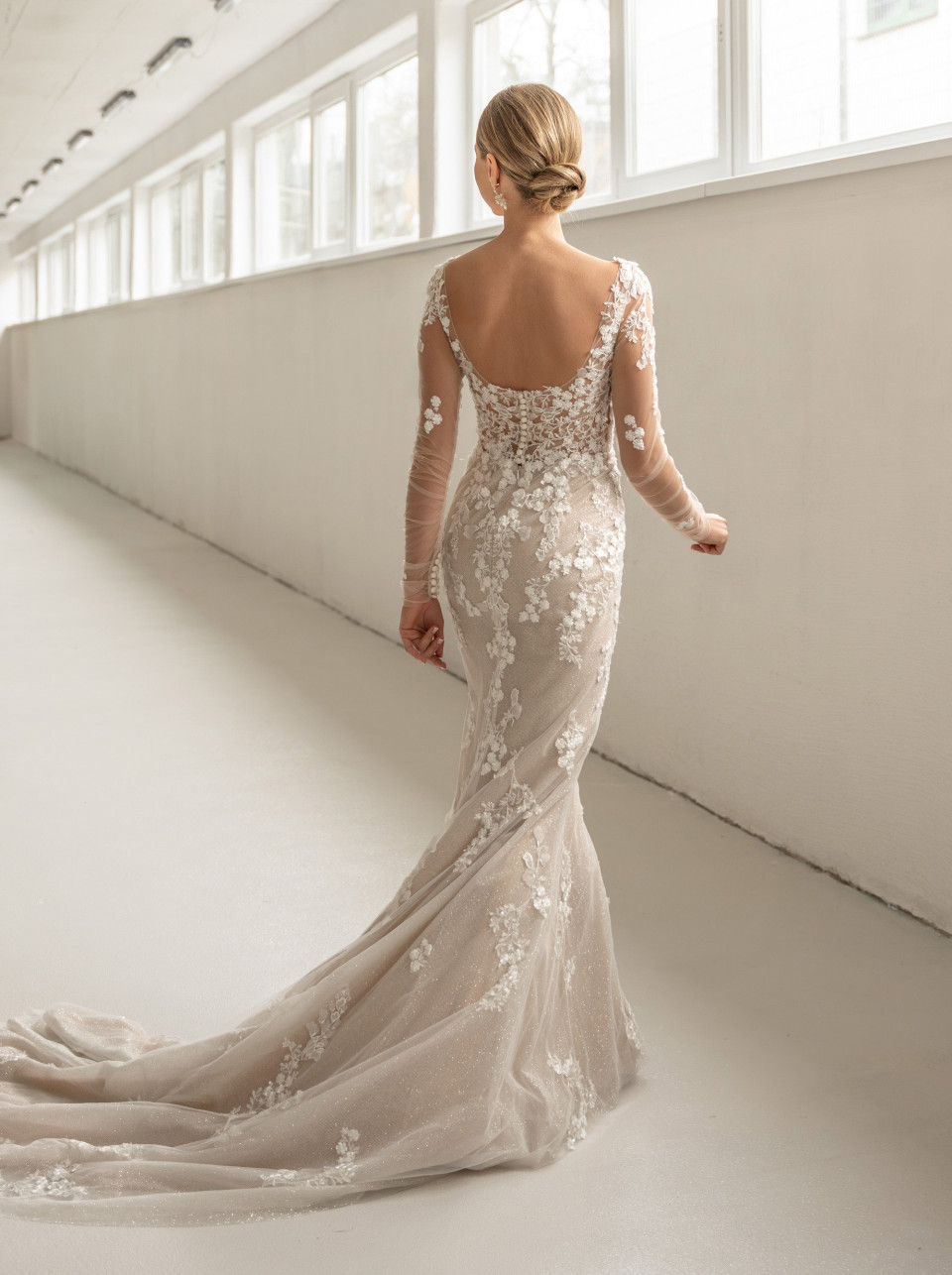 de achterkant van een vrouw die een elegante trouwjurk draagt