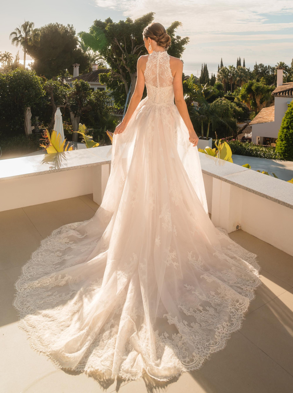 een vrouw in een trouwjurk die op een balkon staat