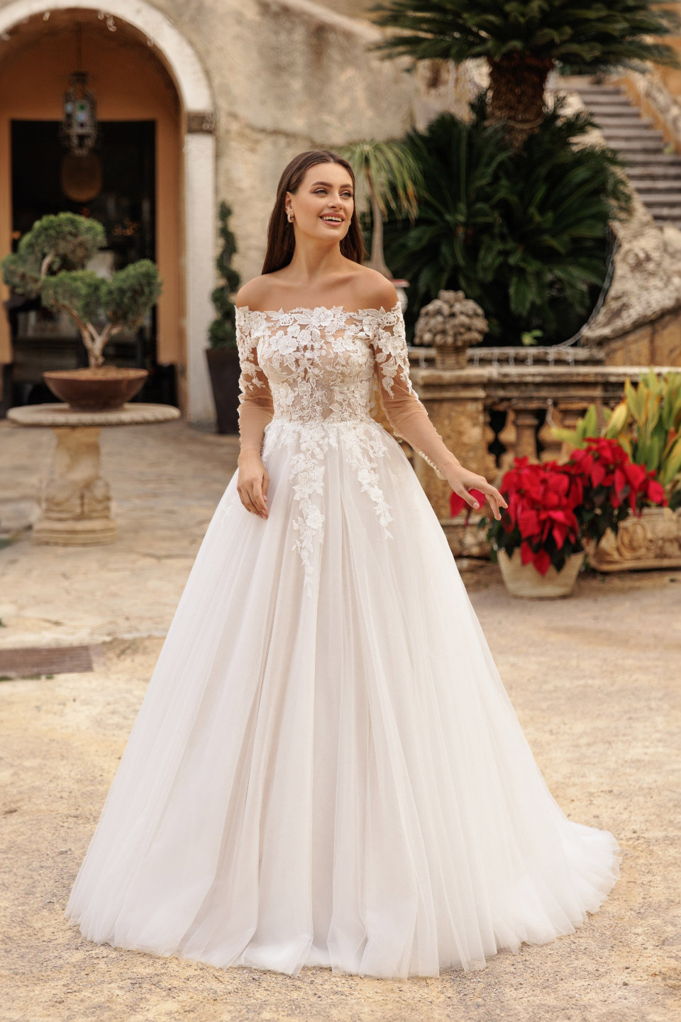 de bruid draagt een trouwjurk met off-shoulder mouwen en een tule rok