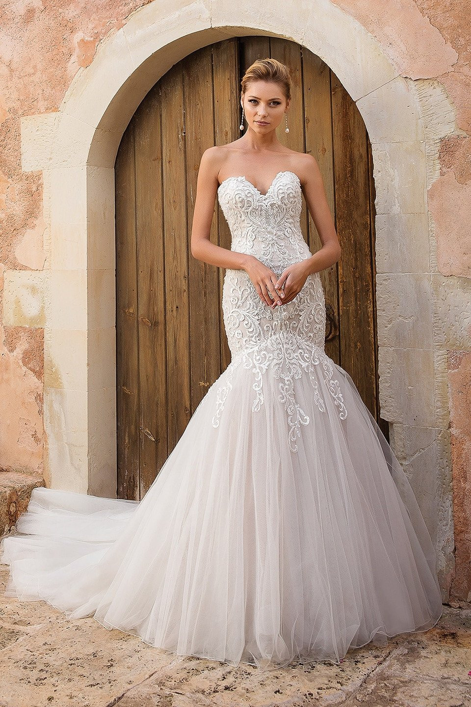 de trouwjurk is gemaakt van tule en kant