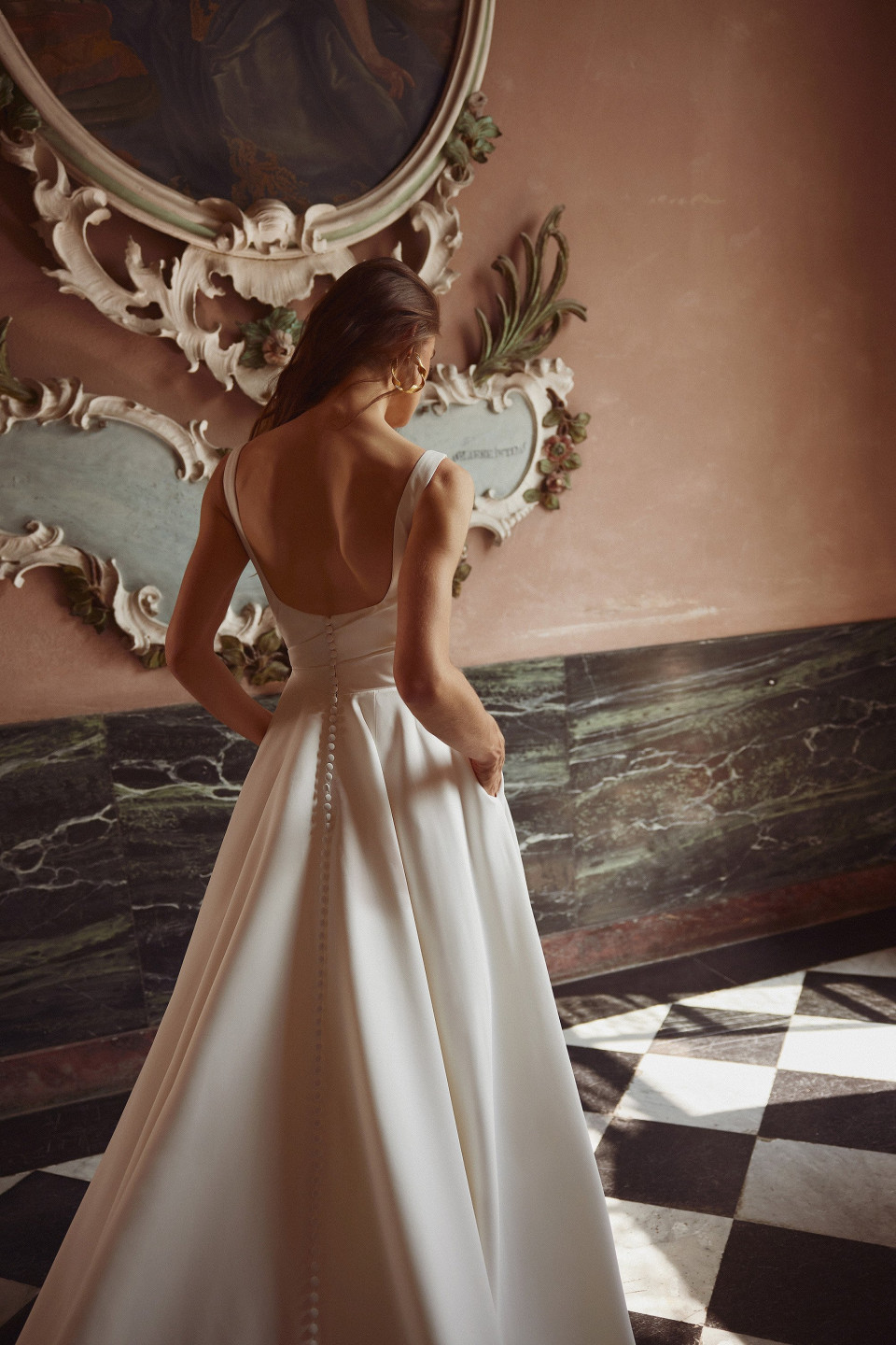 een vrouw in een trouwjurk die voor een spiegel staat