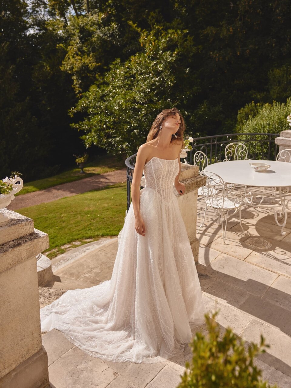 een vrouw in een trouwjurk staand op een patio